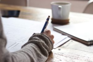 Photo of a woman writing in a notebook.