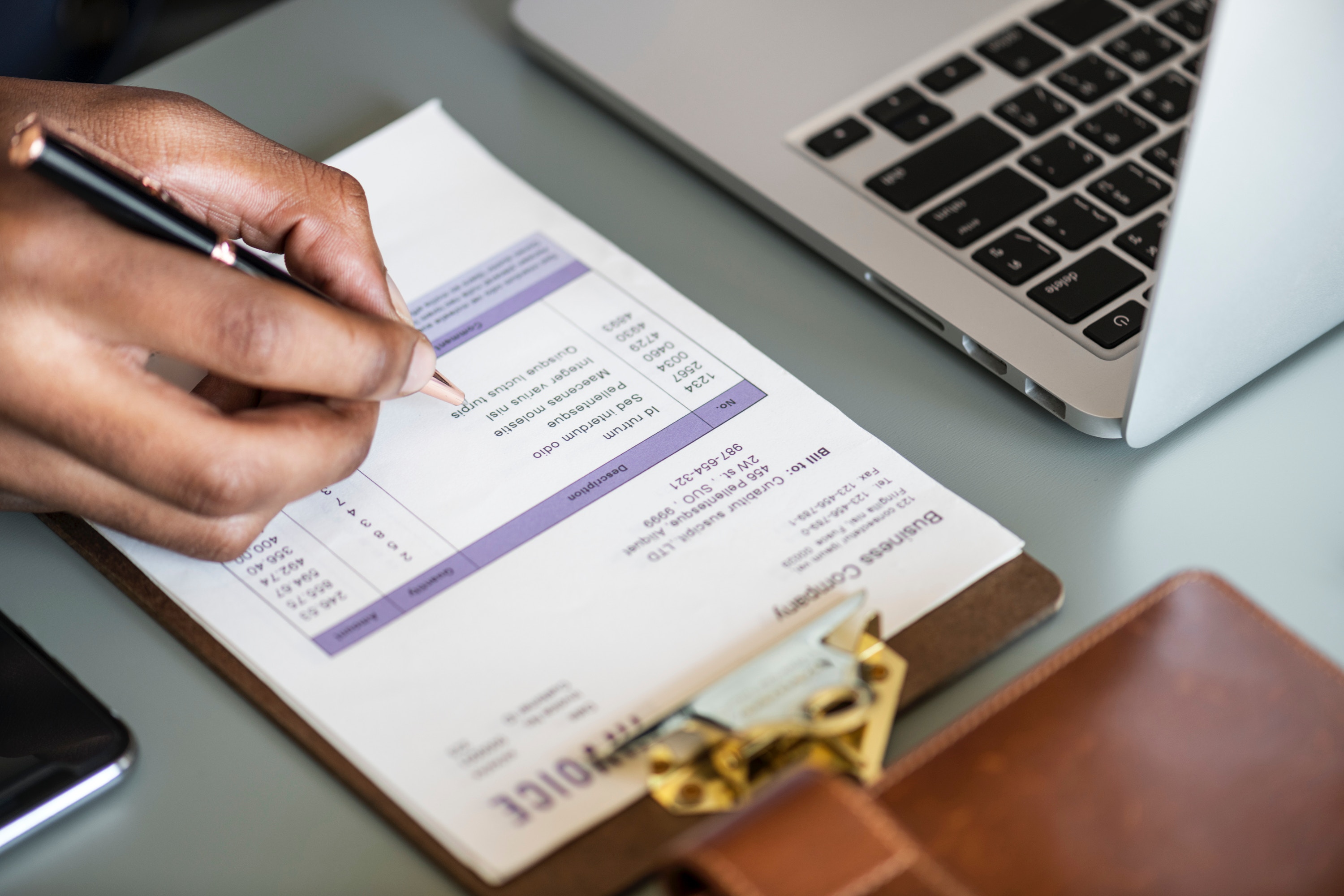 Photo of a man tallying expenses on an invoice.