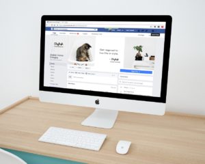 Photo of a Facebook profile page on a large monitor.