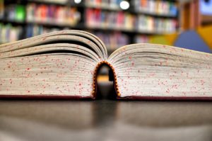 Photo of an open textbook inside a library.