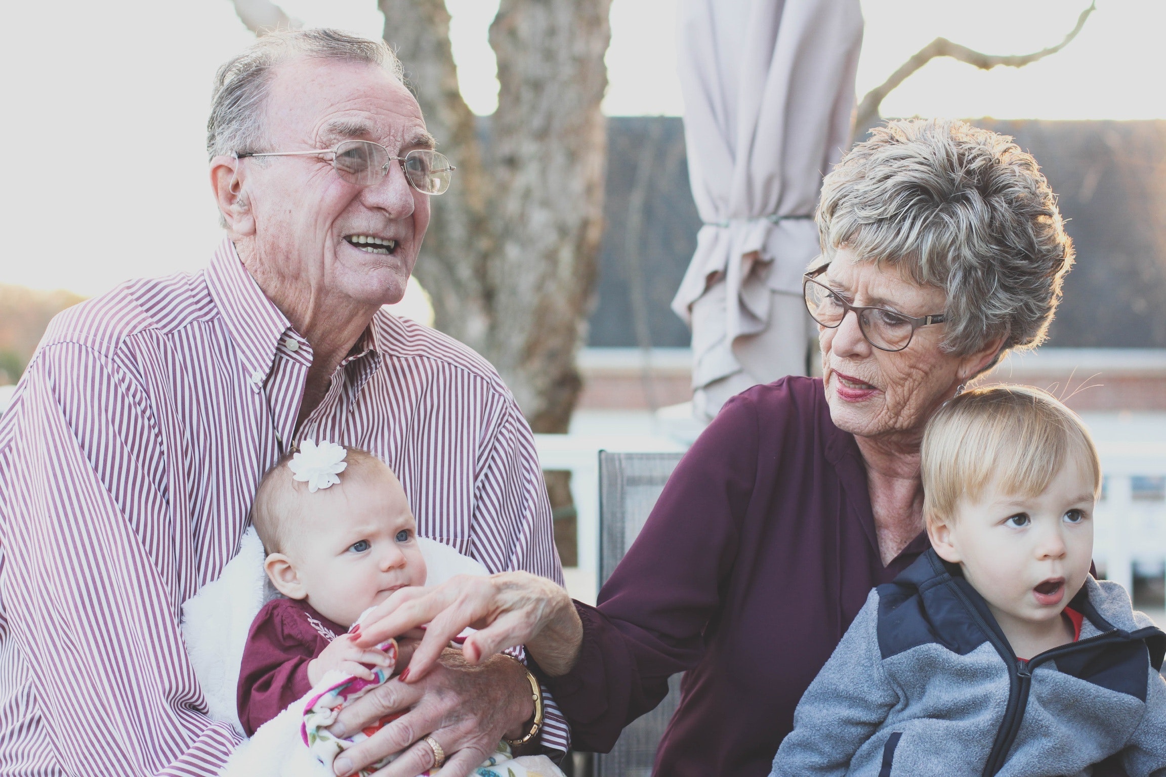 Photo of two grandparents holding their grandchildren.